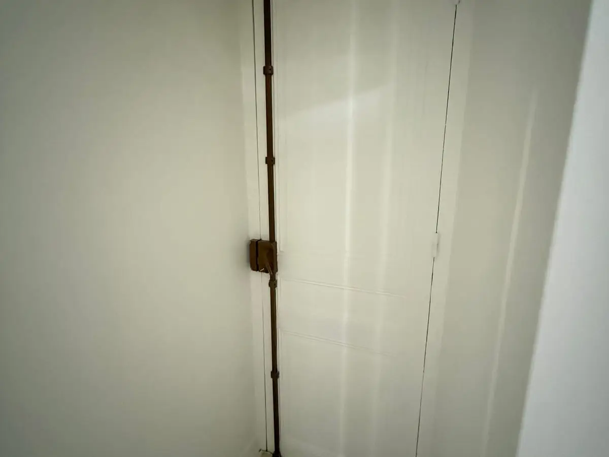 Crémone verticale sur une porte de service repeinte