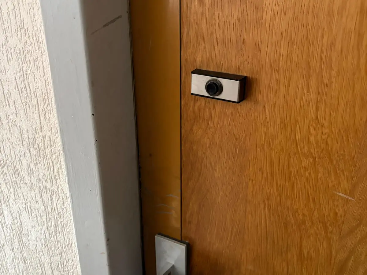Judas optique et serrure encastrée sur une porte palière en bois